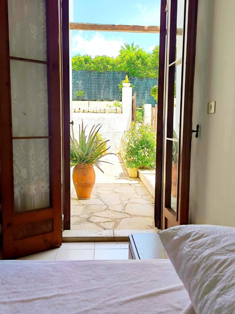 une porte ouverte sur une terrasse avec une plante en pot dans l'établissement Nettuno 2023, à Marina di Ragusa