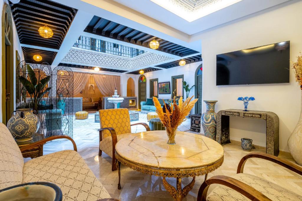 un salon avec une table et des chaises dans l'établissement Riad Hamdane et SPA, à Marrakech
