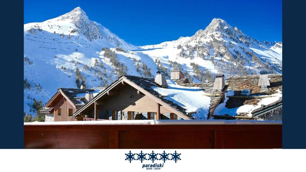 une montagne enneigée avec une maison au premier plan dans l'établissement ARC 1950 - cozy apartment with mountain view, à Arc 1950 20 autres photos