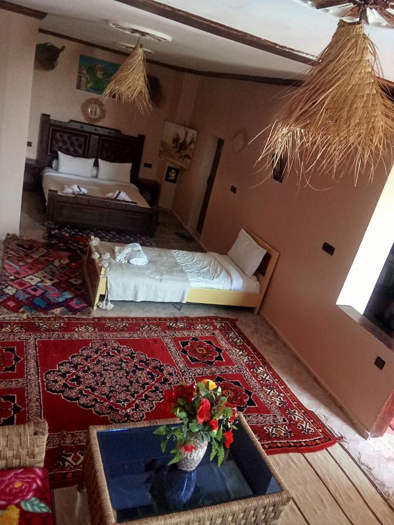 - une chambre d'hôtel avec un lit et un lit dans l'établissement kasbah amlal, à Boumalne