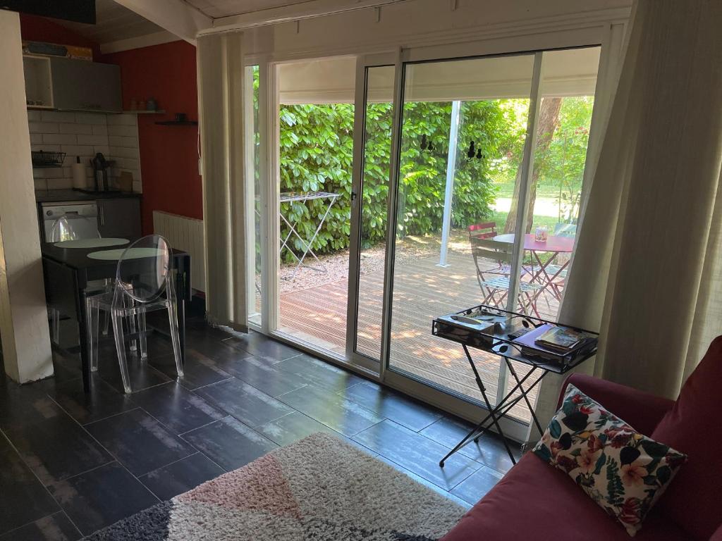 d'un salon avec une porte coulissante en verre menant à une terrasse. dans l'établissement Gîte de charme Jas de Berrias Ardèche du Sud Piscine, à Berrias Et Casteljau