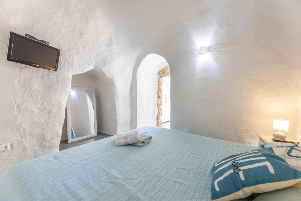 - une chambre avec un lit et une télévision murale dans l'établissement Villa Dama, à Marina di Mancaversa