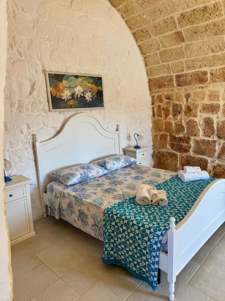 une chambre avec un lit dans un mur de pierre dans l'établissement Villa Donatella, à Alessano