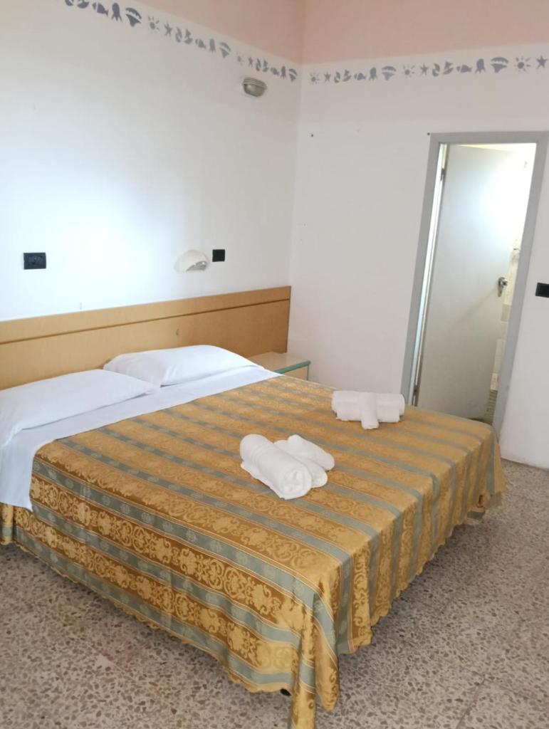 une chambre avec un lit avec deux serviettes dessus dans l'établissement Hotel sidney, à Bellaria-Igea Marina