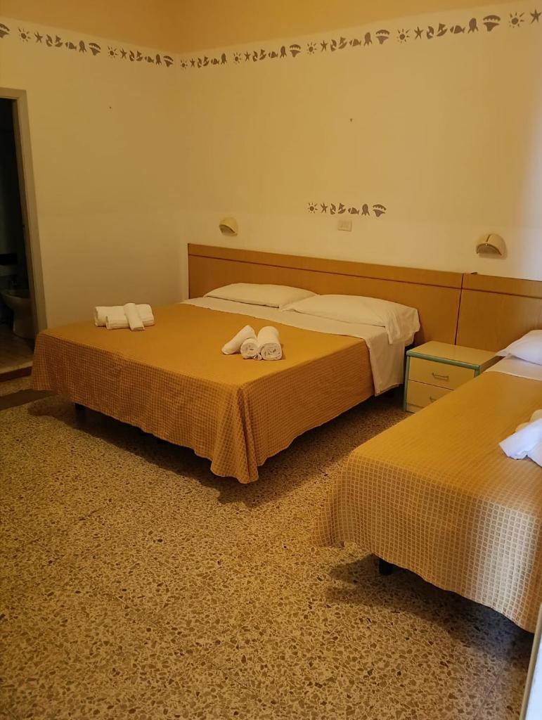 deux lits dans une chambre d'hôtel avec des serviettes dessus dans l'établissement Hotel sidney, à Bellaria-Igea Marina