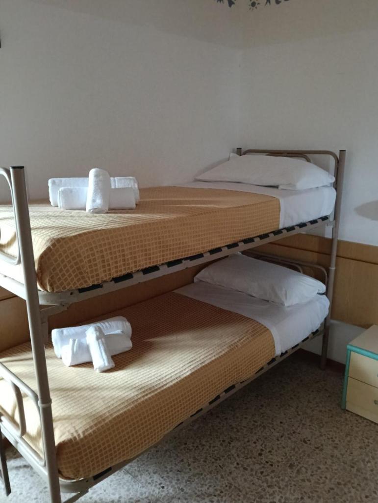 une chambre avec deux lits superposés avec des serviettes dessus dans l'établissement Hotel sidney, à Bellaria-Igea Marina