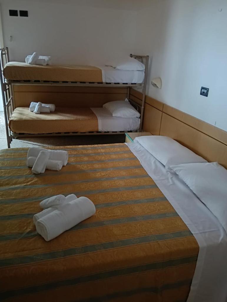 - 2 lits dans une chambre avec des serviettes blanches dans l'établissement Hotel sidney, à Bellaria-Igea Marina