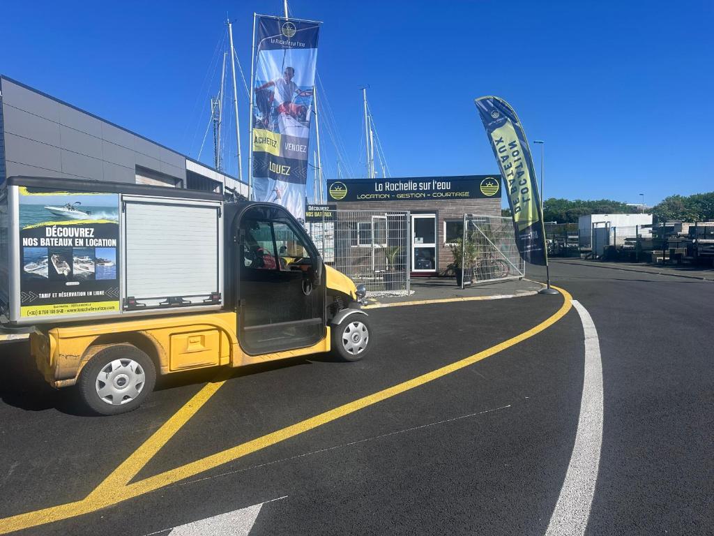 une petite voiture jaune garée sur un parking dans l'établissement La Rochelle sur L'eau, à La Rochelle