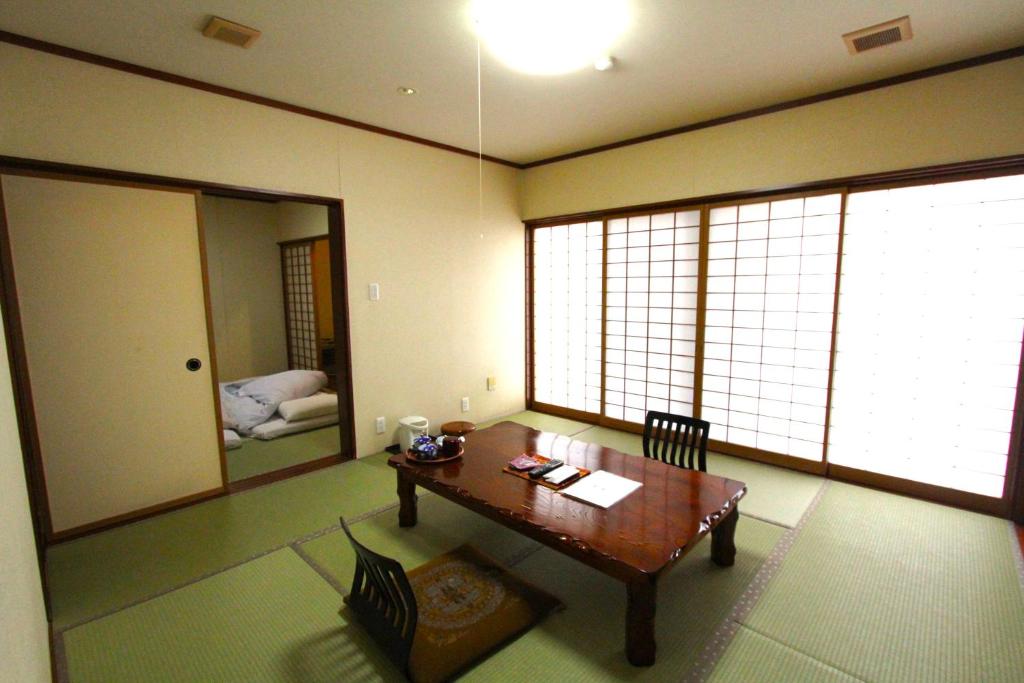 une chambre avec une table et une chambre avec une chambre dans l'établissement ひらゆの森別邸湯う香三蔵庵, à Takayama