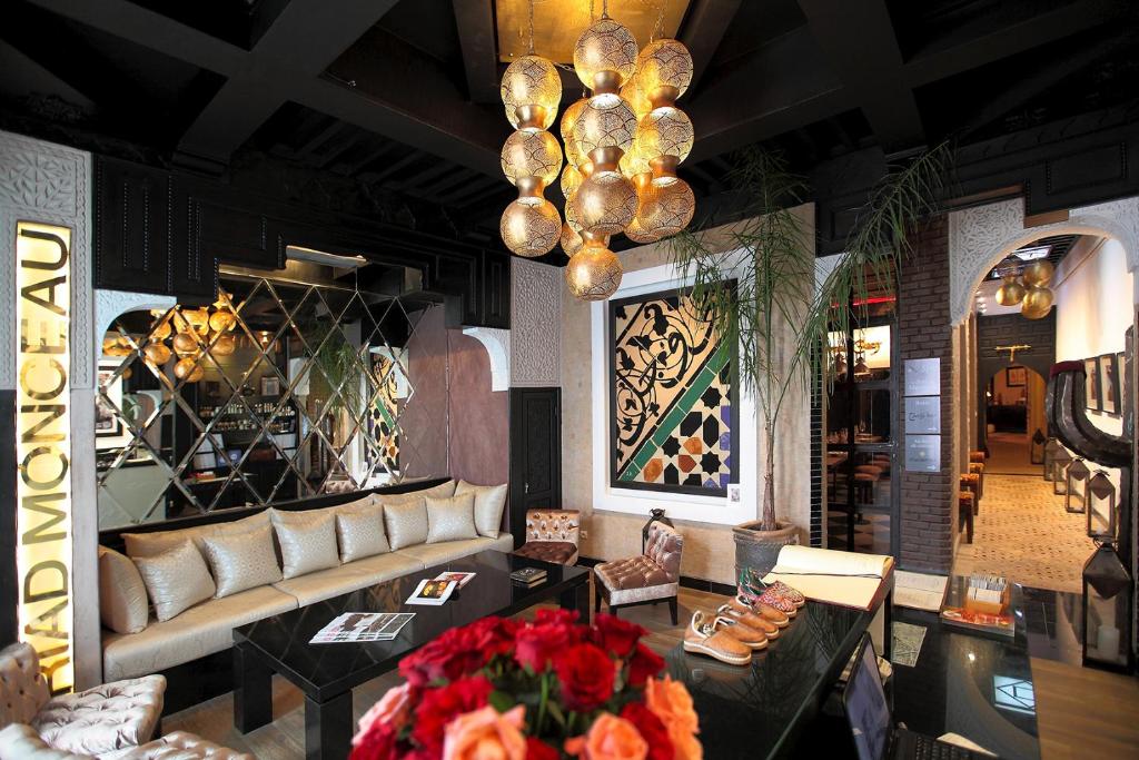 - un hall avec un canapé, des tables et un lustre dans l'établissement Riad Monceau, à Marrakech