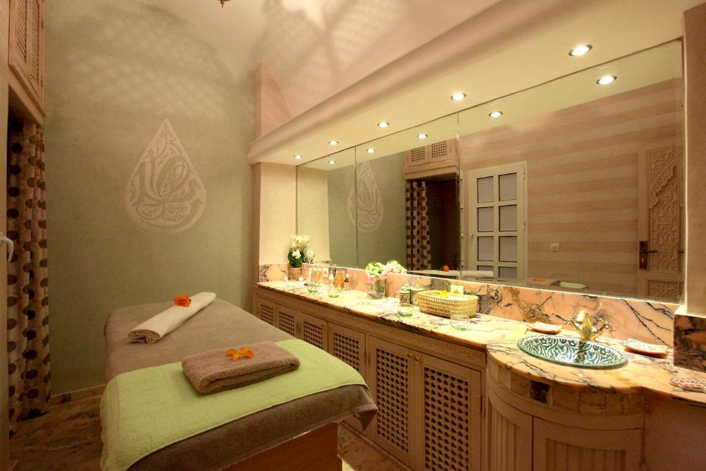 une salle de bain avec un lavabo et un grand miroir dans l'établissement Riad Monceau, à Marrakech