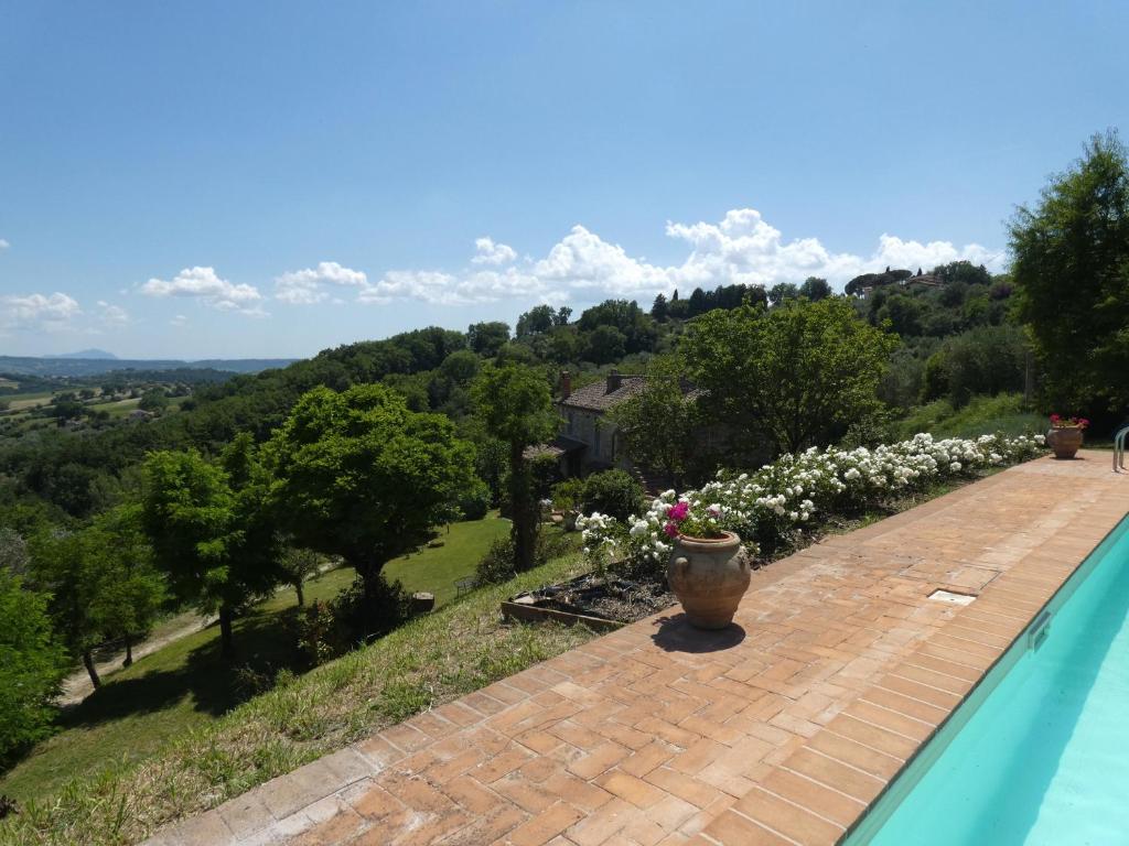 une piscine avec un vase au bord d'une maison dans l'établissement SCAPPO IN UMBRIA, il Fienile, à Fornole