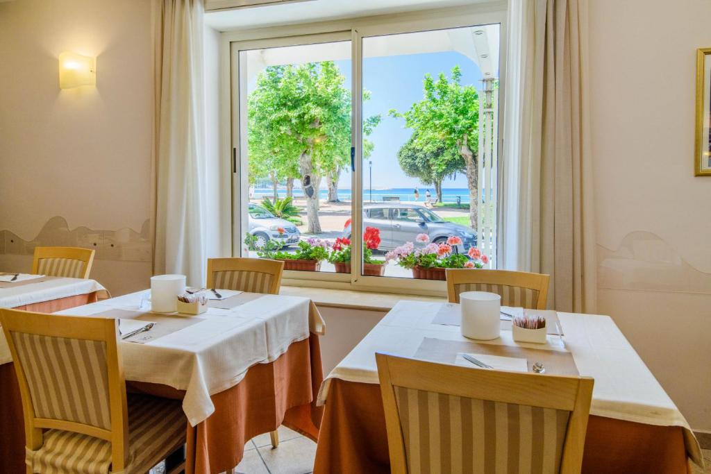 un restaurant avec deux tables et une fenêtre dans l'établissement Hotel Tirreno, à Sapri