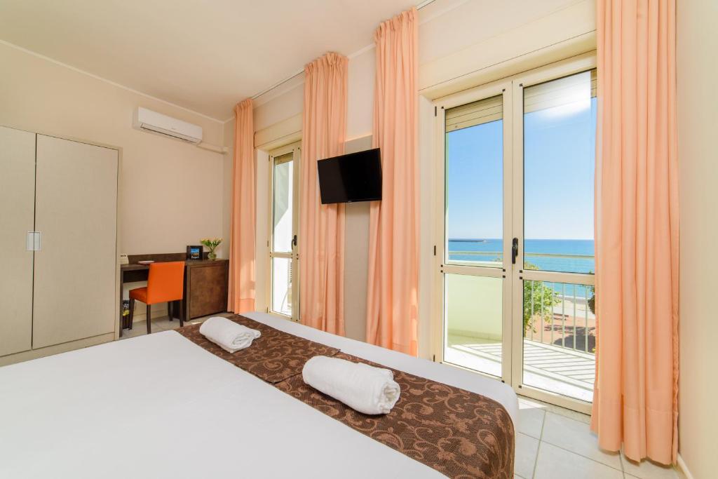 une chambre avec un lit et une grande fenêtre dans l'établissement Hotel Tirreno, à Sapri