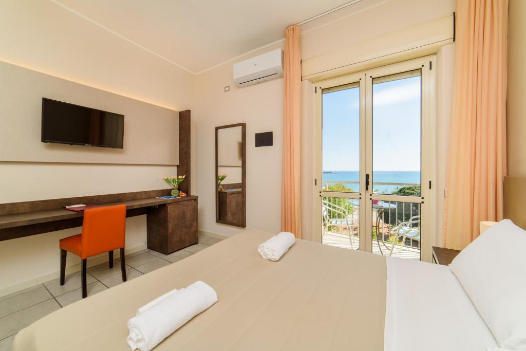 une chambre avec un lit, un bureau et une fenêtre dans l'établissement Hotel Tirreno, à Sapri 133 autres photos