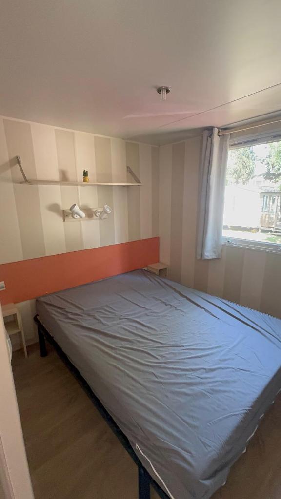 une chambre avec un lit dans une pièce avec une fenêtre dans l'établissement Mobil-home Le Manosely confort 6 pers Climatisé, à Agde 37 autres photos