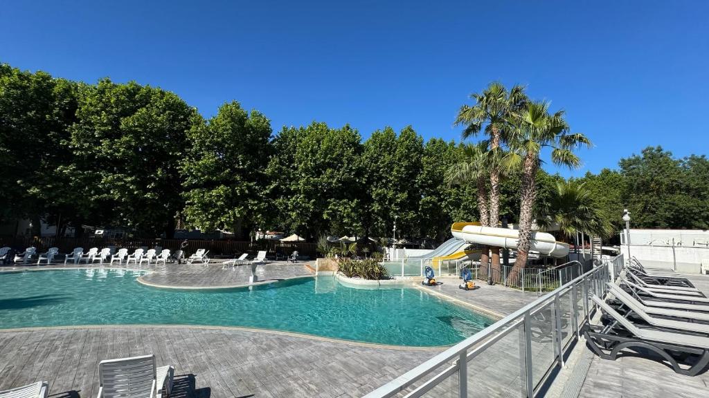 - une piscine avec toboggan dans un complexe dans l'établissement Mobil-home Le Manosely confort 6 pers Climatisé, à Agde