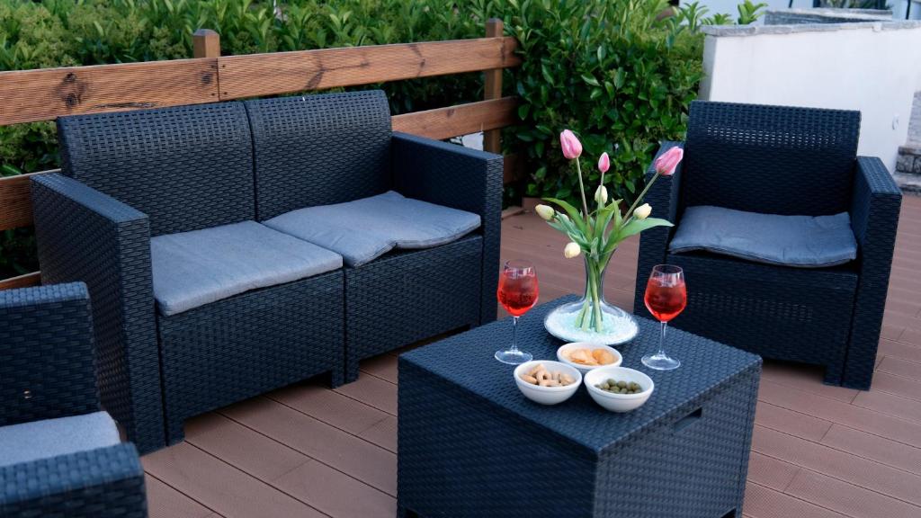 - une terrasse avec 2 chaises et une table avec des verres à vin dans l'établissement Antica Foggia Vetere villa con piscina, à Ceglie Messapica