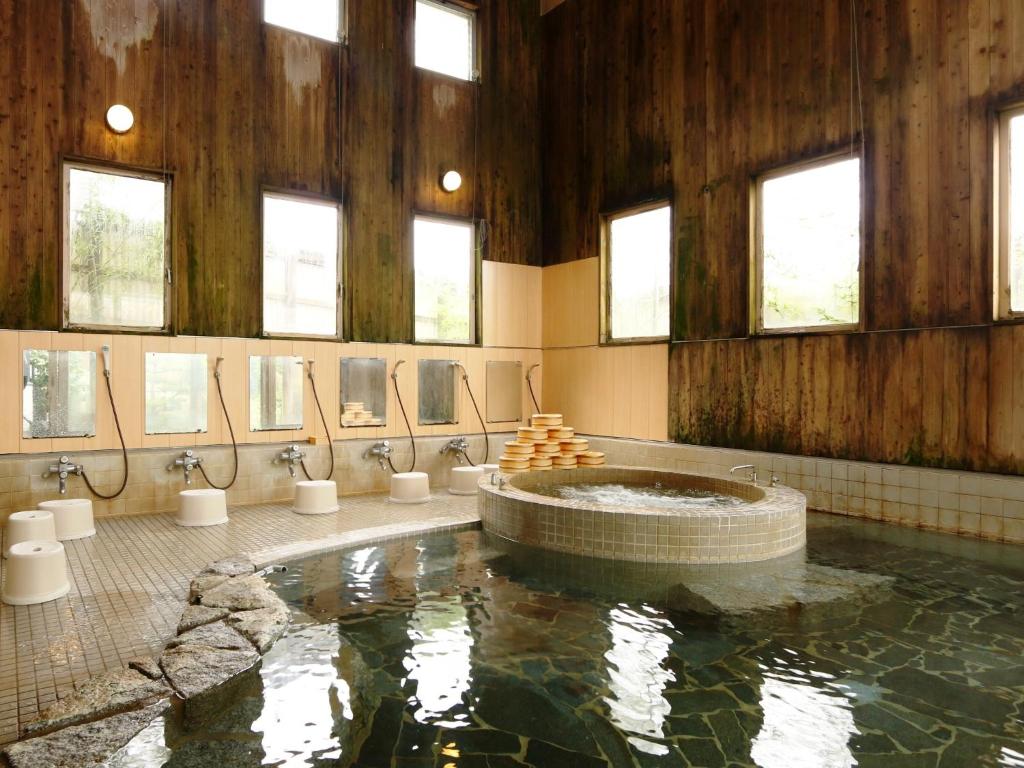 - une grande salle de bains avec une grande piscine d'eau dans l'établissement Ryokan Kamomeso, à Sado