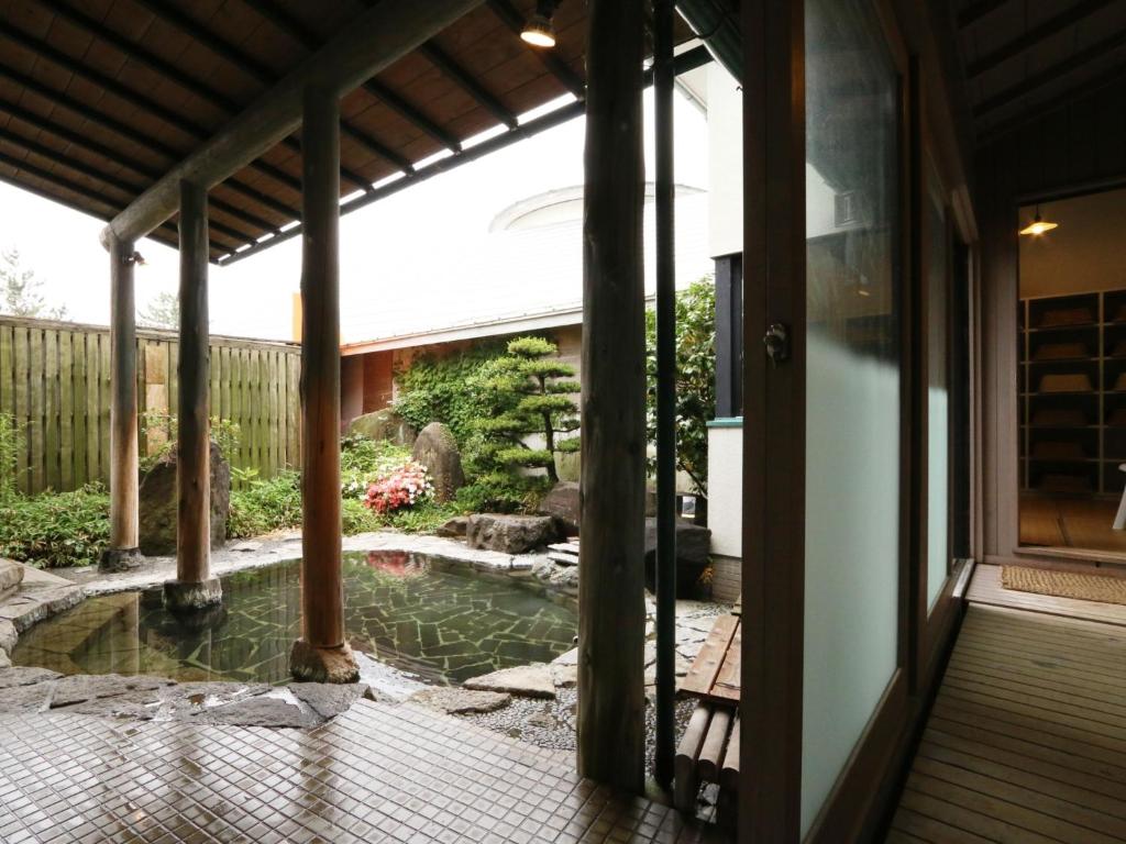 - une vue sur le jardin depuis la terrasse couverte d'une maison dans l'établissement Ryokan Kamomeso, à Sado