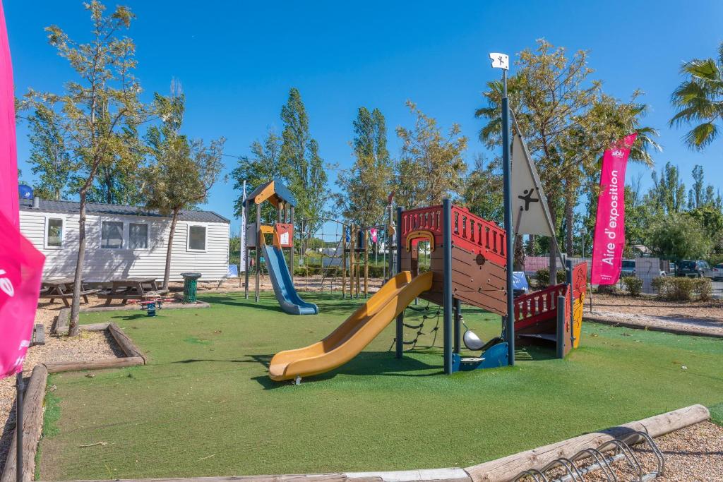 une aire de jeux avec un toboggan dans un parc dans l'établissement Le Mediterranéen, à Fréjus