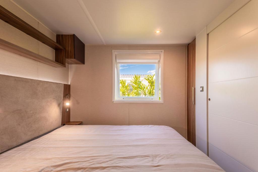 une chambre avec un lit et une fenêtre dans l'établissement Le Mediterranéen, à Fréjus