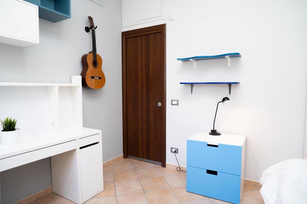 une cuisine avec un placard bleu et une guitare au mur dans l'établissement Moderna villa con piscina a due Passi dal Golf Club, à Pavona