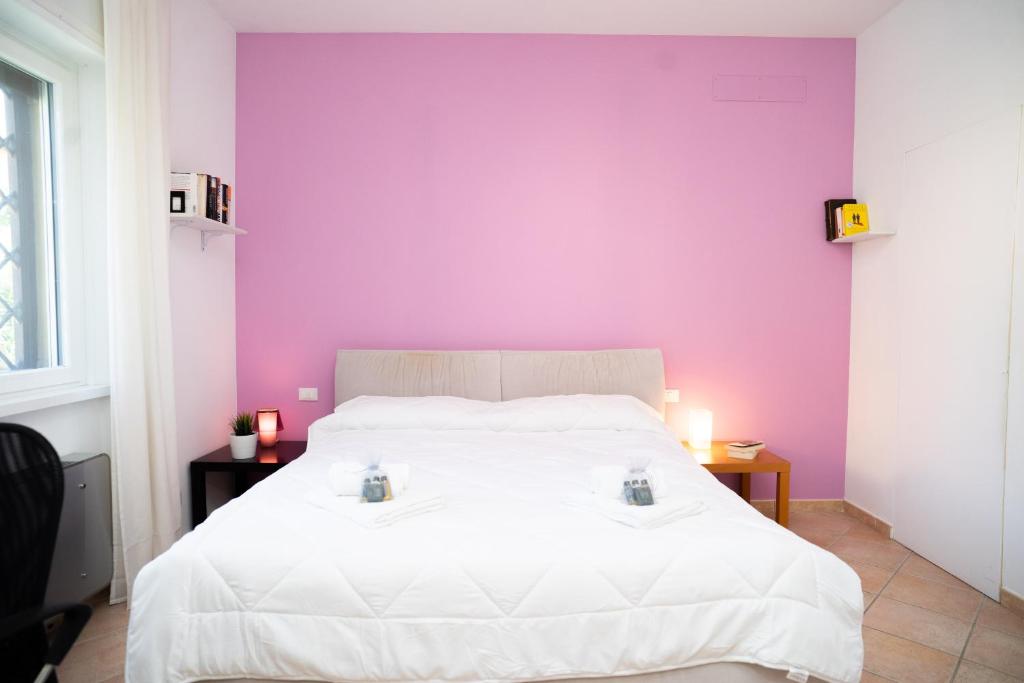 une chambre avec un lit blanc avec un mur violet dans l'établissement Moderna villa con piscina a due Passi dal Golf Club, à Pavona 25 autres photos