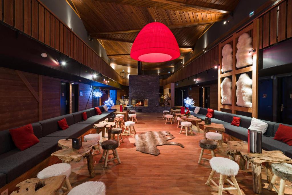 un restaurant avec des tables et des chaises et une lumière rouge dans l'établissement Marmotel & Spa, à Pra-Loup