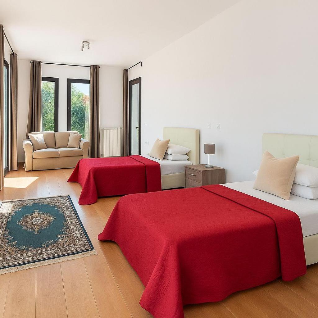 deux lits dans une chambre blanche avec des draps rouges dans l'établissement Villa Flavia, à Polignano a Mare