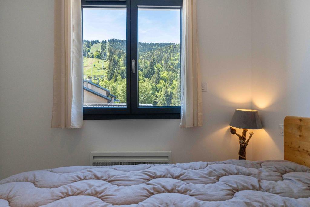 une chambre avec un lit et une fenêtre avec vue dans l'établissement Aux pieds des pistes - Appt A, à Ax-les-Thermes