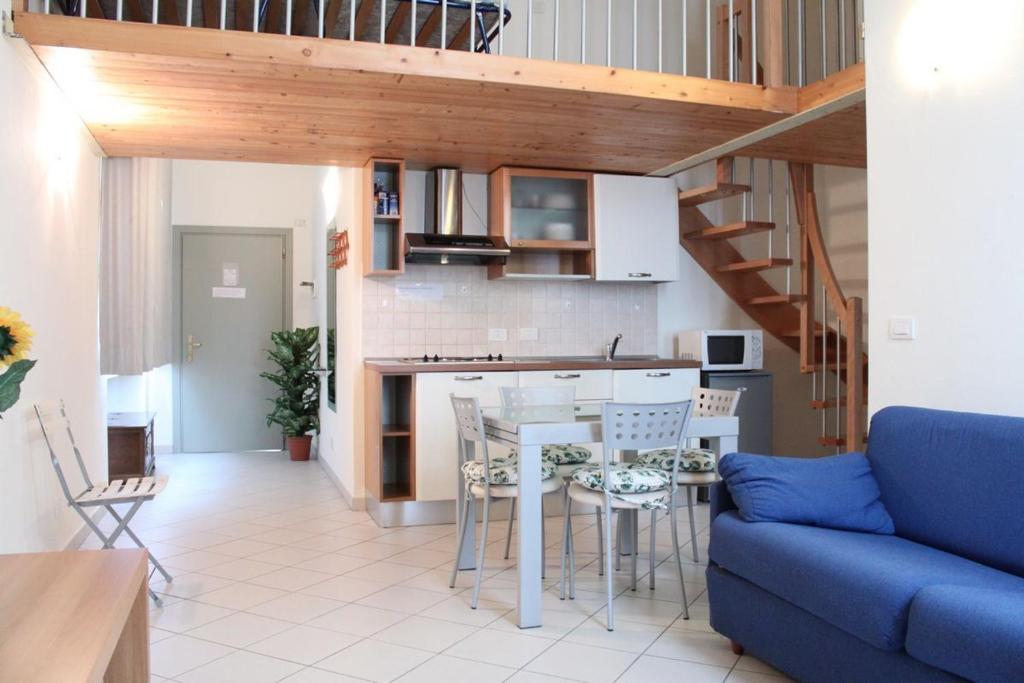 Il comprend une cuisine et un salon avec un canapé bleu. dans l'établissement Residence Villa Marina, à Marina di Ravenna