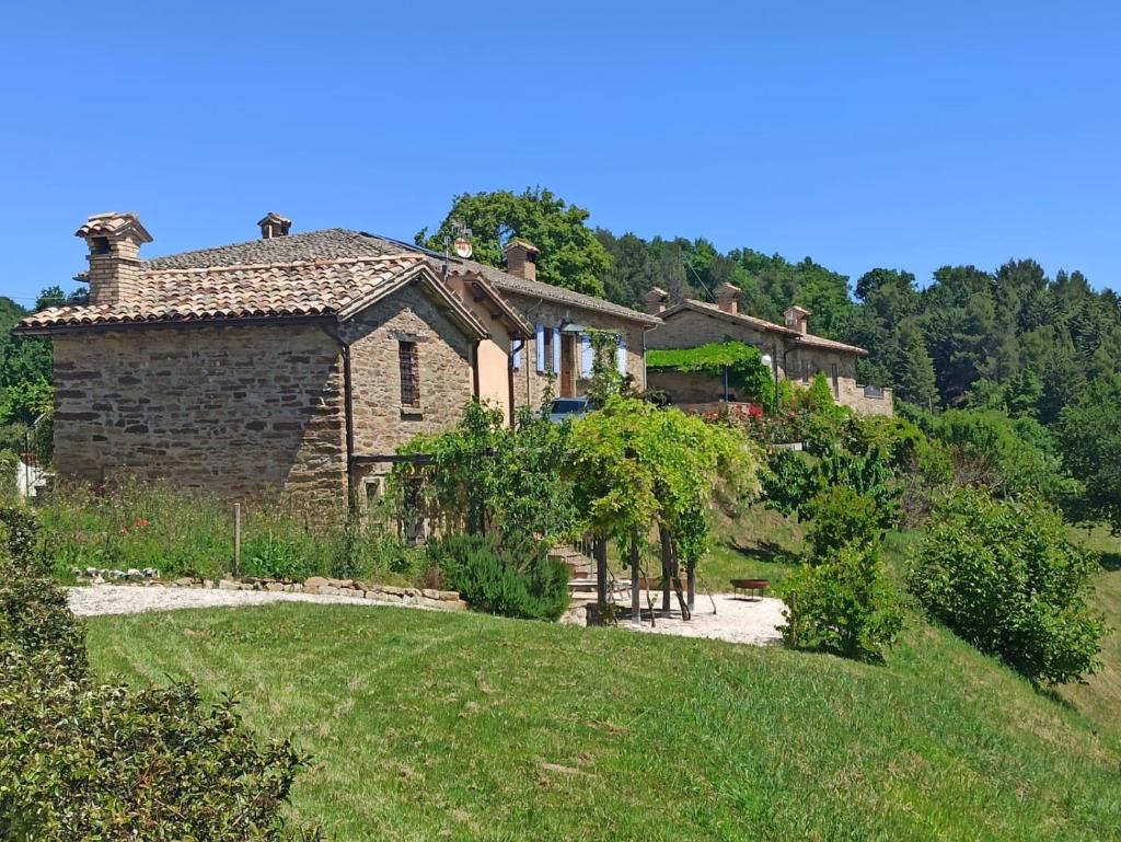 une ancienne maison en pierre sur le côté d'une colline dans l'établissement Ca' Gulino - Urbino - Villa con Minipiscina in Borgo Antico, à Urbino