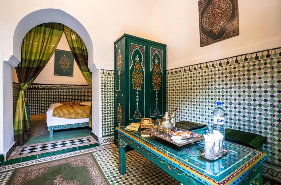 Cette chambre comprend une table et un lit. dans l'établissement Riad 4 Jardins & Spa, à Marrakech