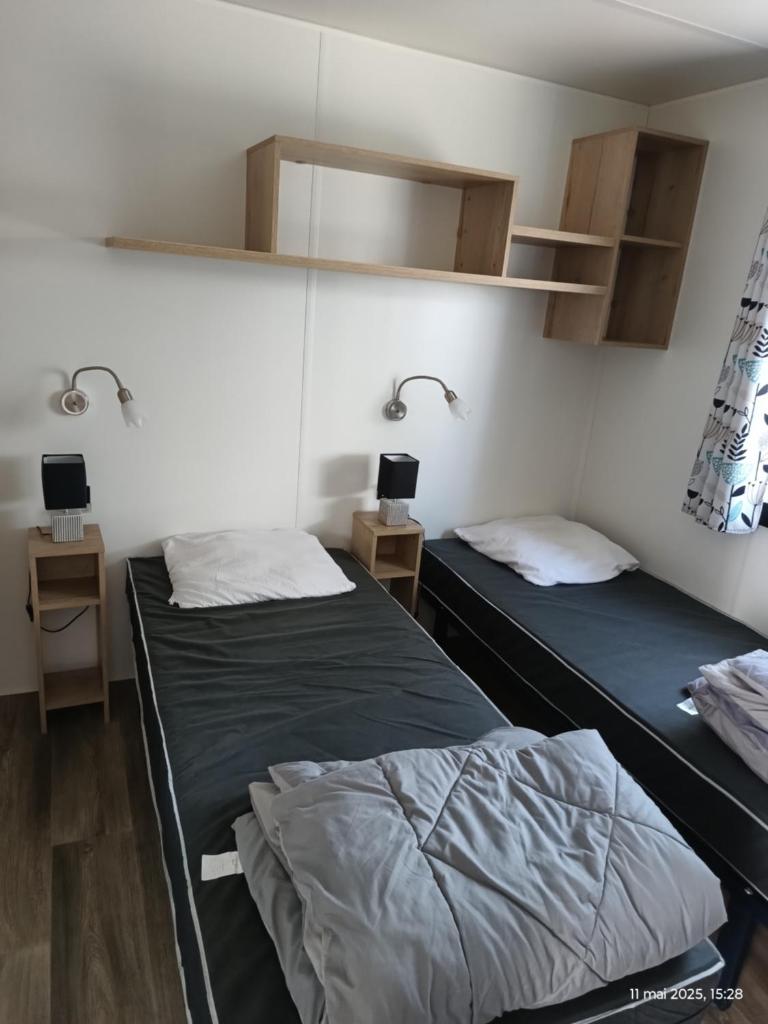 - 2 lits dans une chambre avec 2 tables et 1 lit dans l'établissement Camping SIBLU les sables du midi, à Valras-Plage