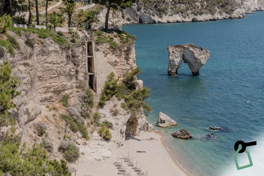 - une vue sur une falaise avec une plage et l'océan dans l'établissement HOTIDAY Room Collection - Mattinata Faraglioni, à Mattinata