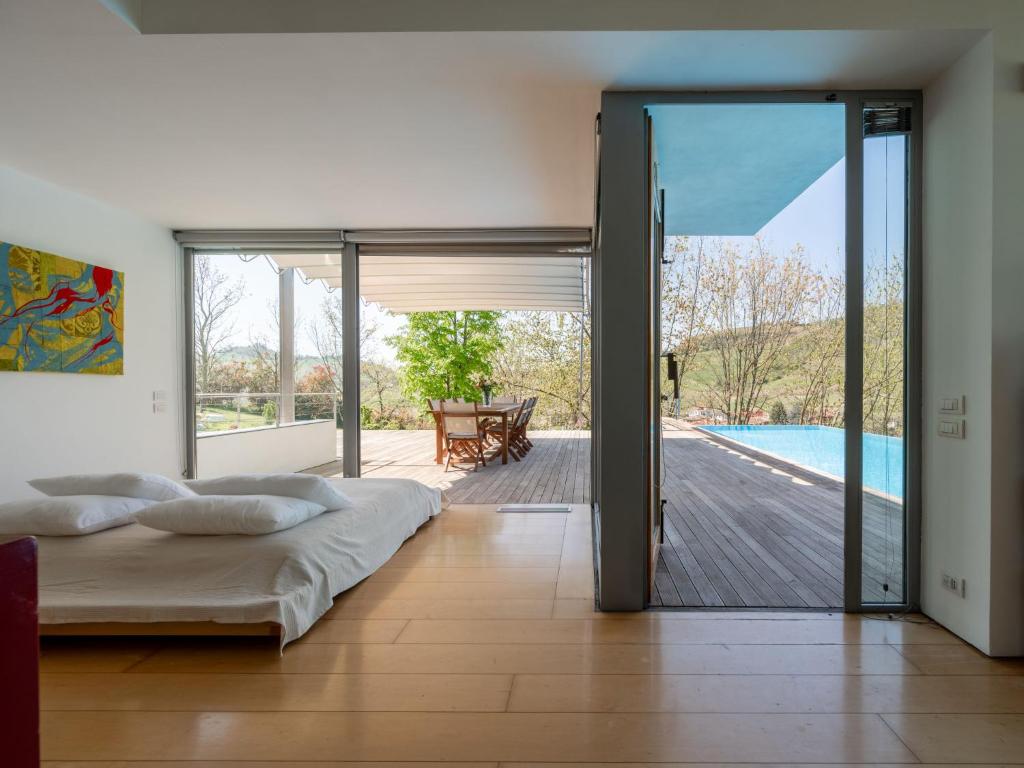 une chambre avec un lit et une porte coulissante en verre dans l'établissement Villa Stordita by Interhome, à Castellinaldo