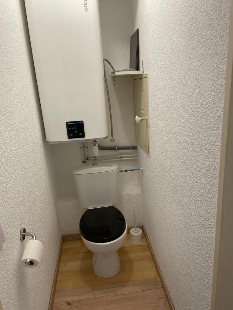 une petite salle de bains avec toilettes et siège noir dans l'établissement La Foux d'Allos, à Allos 11 autres photos