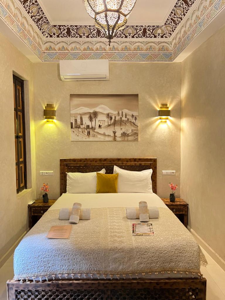 une chambre avec un lit avec un tableau sur le mur dans l'établissement Riad Alice Terrace & Spa, à Marrakech