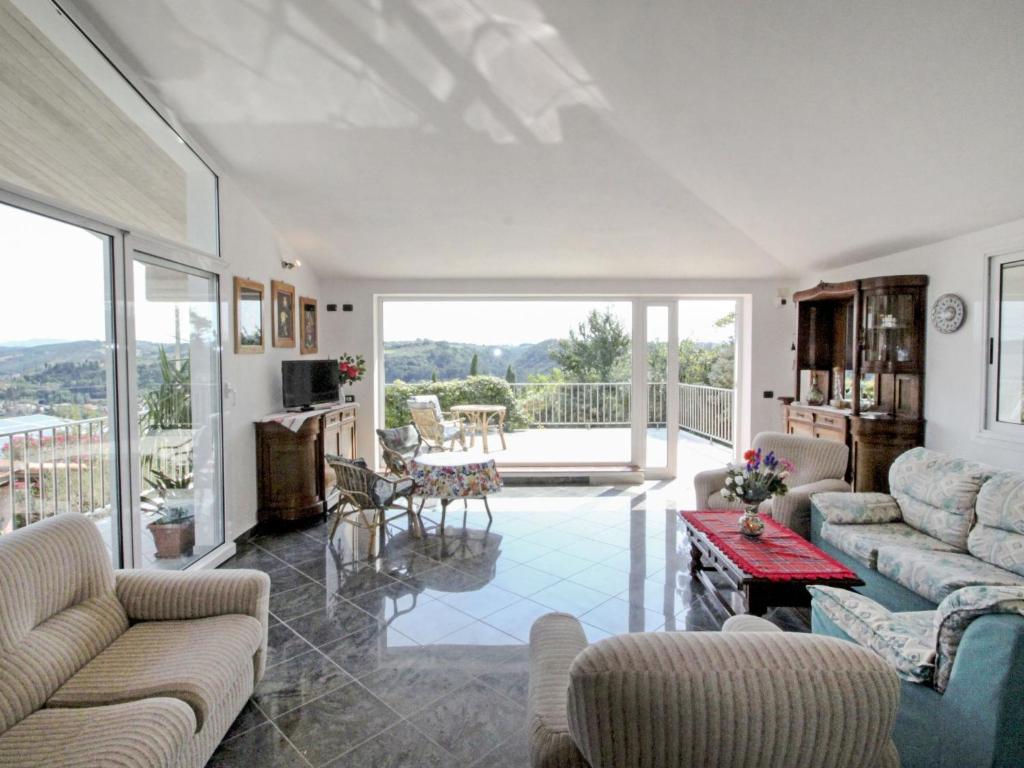 un salon avec des canapés et une table ainsi qu'un balcon dans l'établissement Villa La Rosa by Interhome, à Montelupo Fiorentino