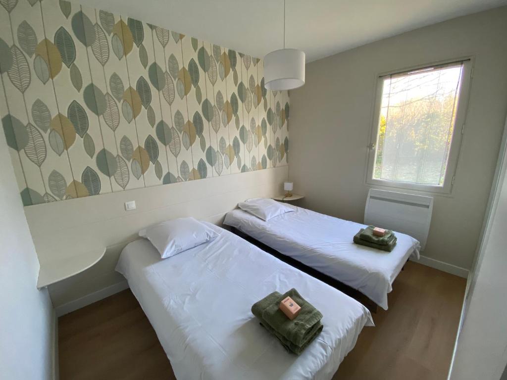une chambre avec deux lits et une fenêtre dans l'établissement camping le Faillal, à Montpezat-de-Quercy