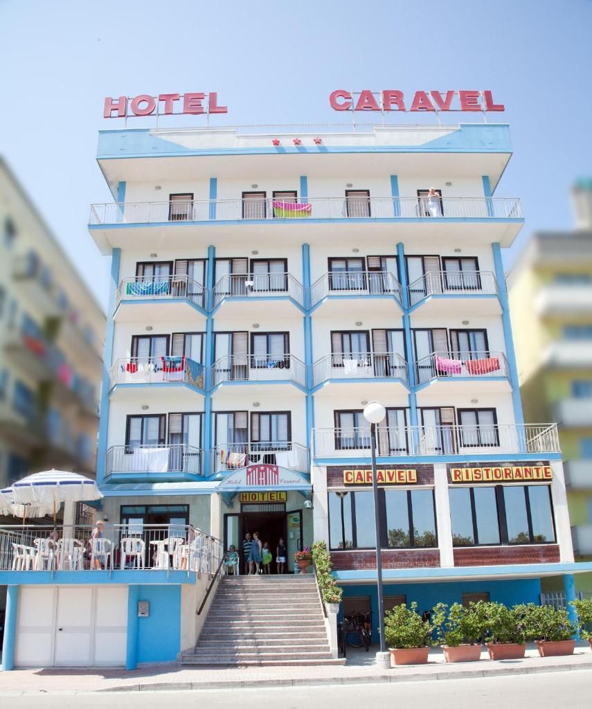 un grand bâtiment avec un escalier devant dans l'établissement Hotel Caravel, à Sottomarina