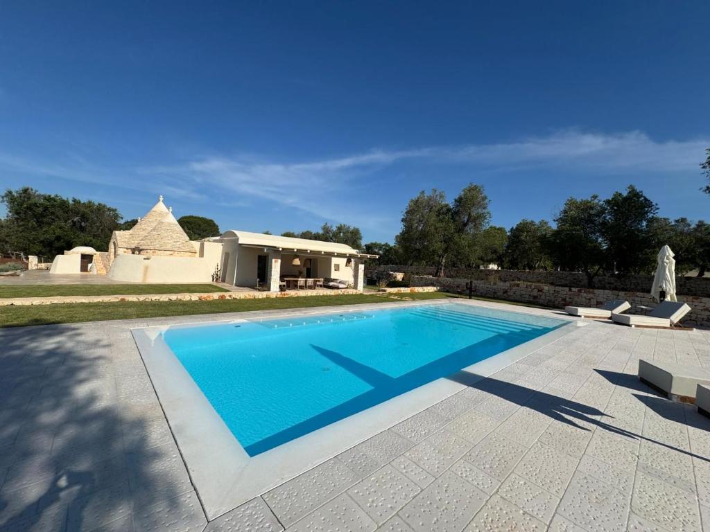 une piscine dans une cour avec une maison dans l'établissement Trullo di Theo, à Ostuni