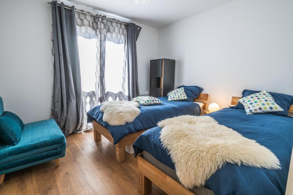 une chambre avec deux lits et une chaise dans l'établissement Le chalet des étoiles, à La Mongie