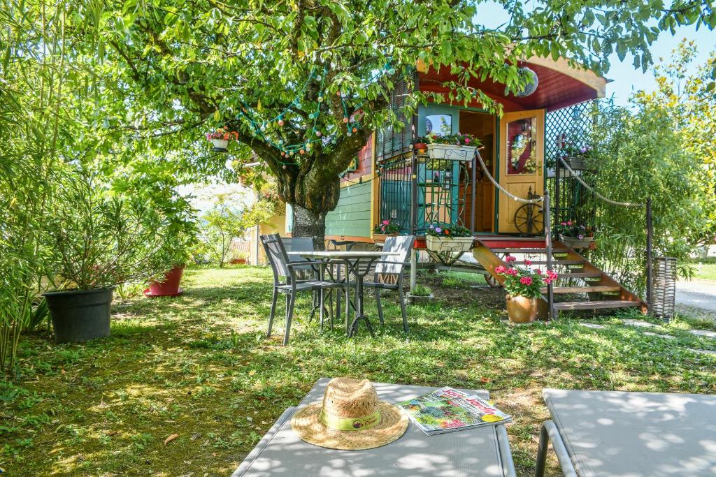 une maison avec une table et des chaises dans la cour dans l'établissement Roulotte de bohême - Praline, à Truison