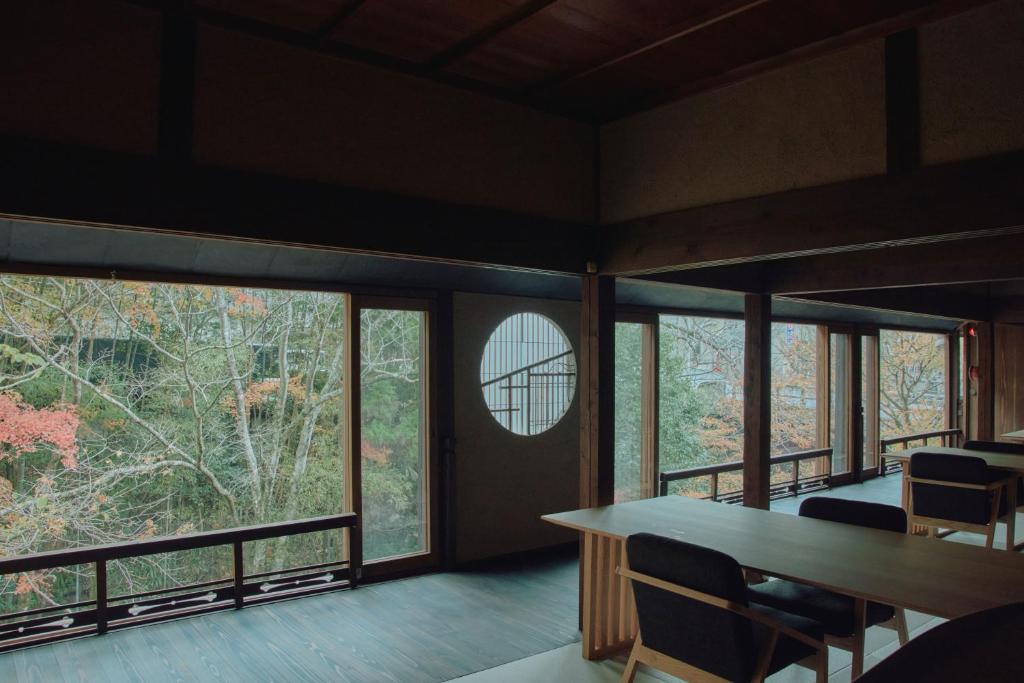 Cette chambre dispose de grandes fenêtres, d'une table et de chaises. dans l'établissement Misenkan, à Tenkawa
