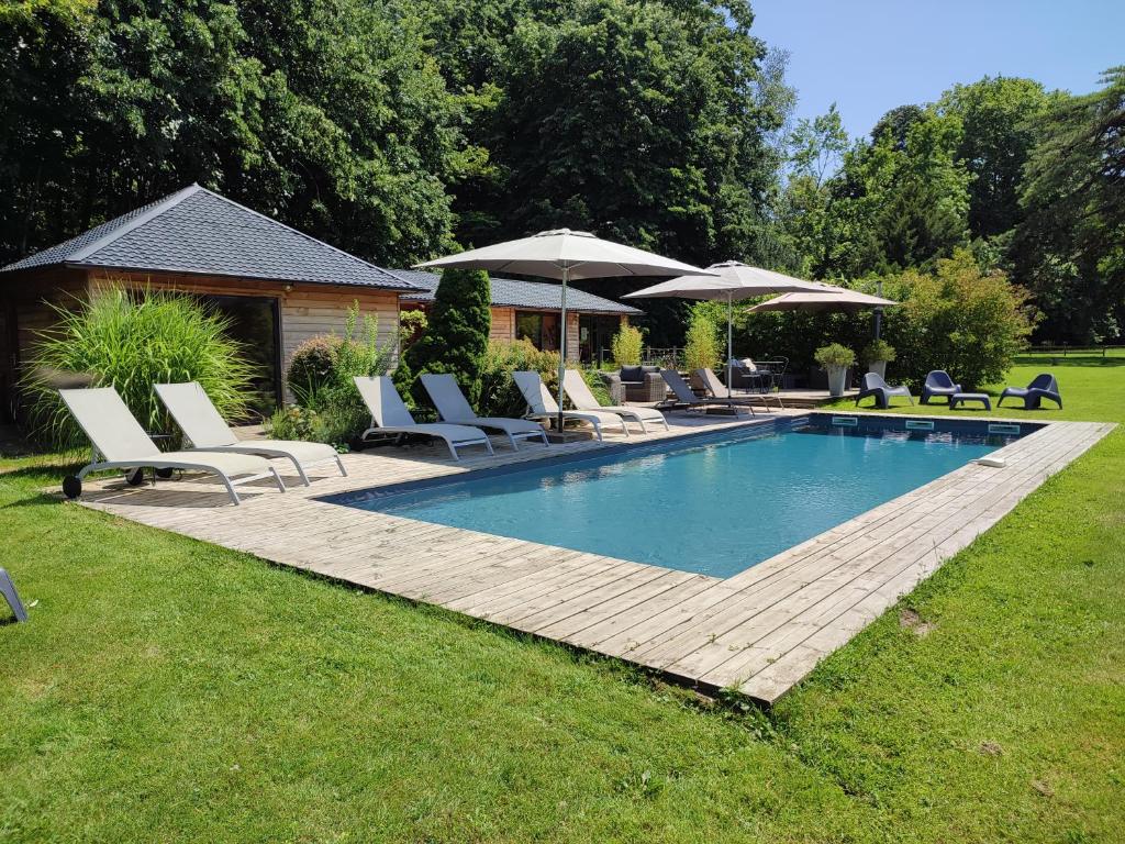 une piscine avec chaises longues et parasols dans l'établissement Cabane Aligoté, à Saint-Albain