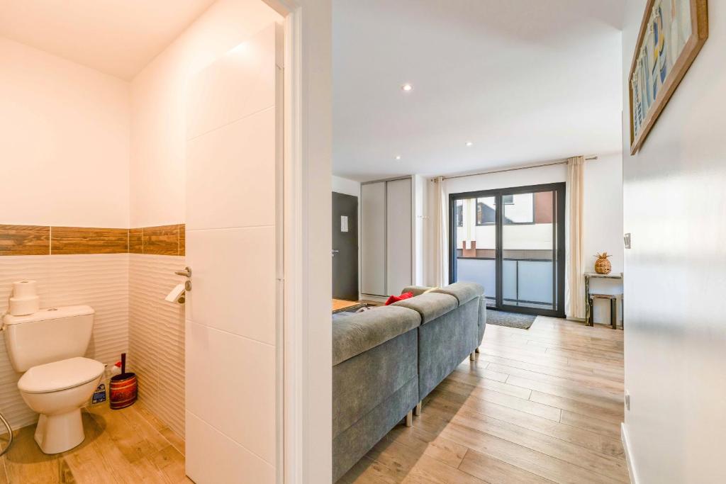 - un salon avec un canapé et des toilettes dans l'établissement Aux pieds des pistes - Appt A, à Ax-les-Thermes