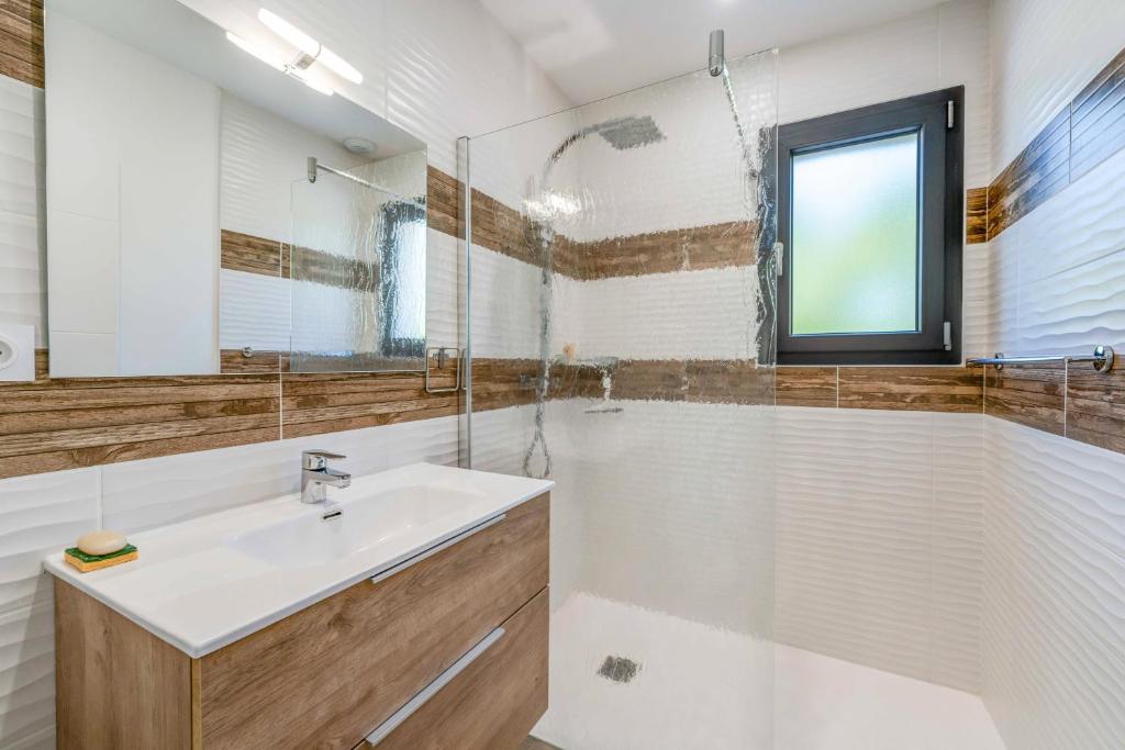 une salle de bain blanche avec un lavabo et une douche dans l'établissement Aux pieds des pistes - Appt A, à Ax-les-Thermes 12 autres photos