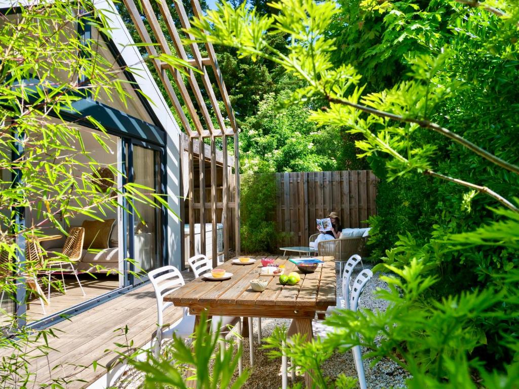 - une table et des chaises en bois dans le jardin dans l'établissement Camping La Forêt, à Saint-Jean-de-Monts